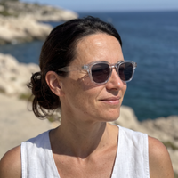 Femme portant Le Levant Olive en plein soleil, monture cristal, verres foncés