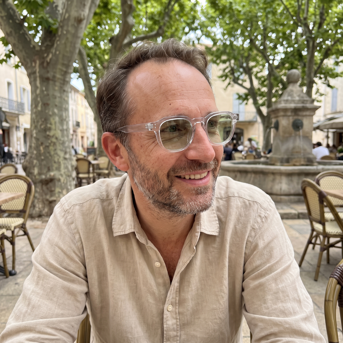 Homme portant Le Levant Olive à l'ombre, monture cristal, verres vert clair