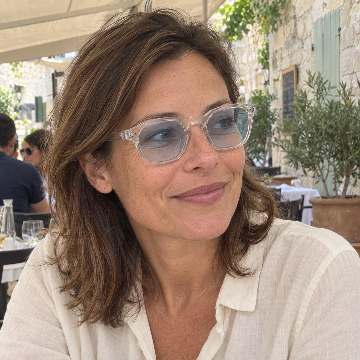 Femme portant Le Levant Riviera à l'ombre, monture cristal, verres bleu clair