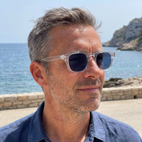 Homme portant Le Levant Riviera en plein soleil, monture cristal, verres bleu foncé