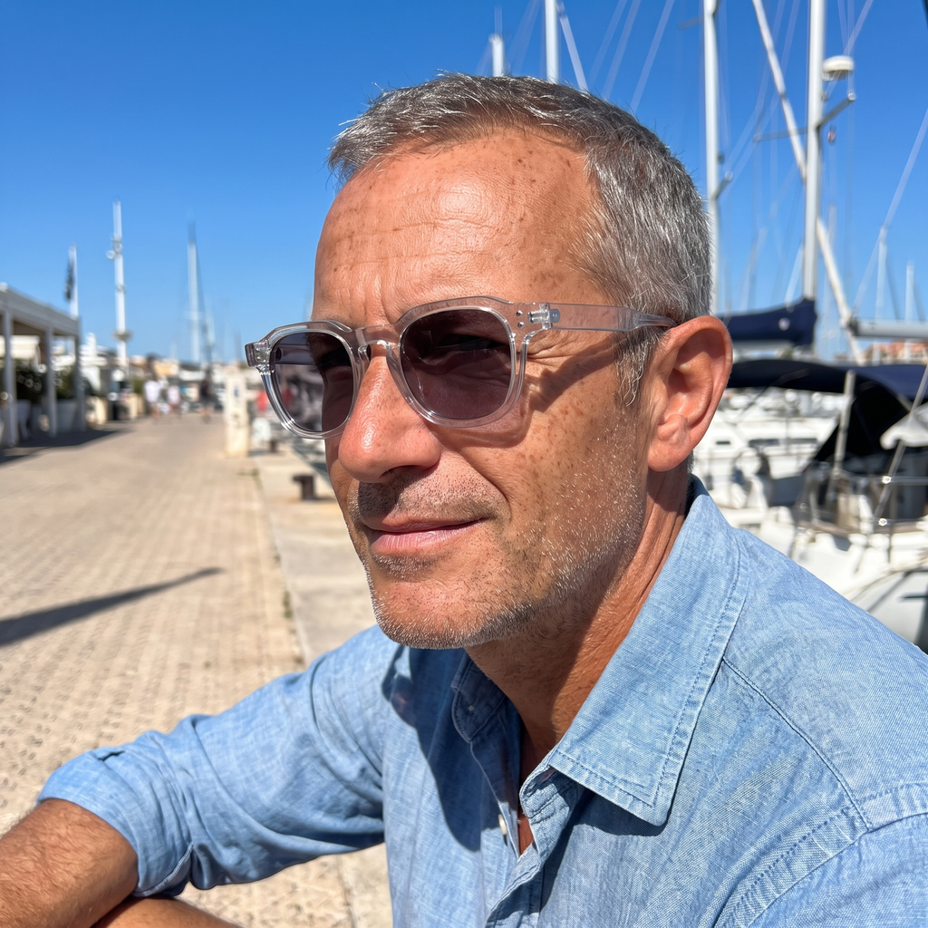 Homme portant Le Levant Rosé en plein soleil, monture cristal, verres foncés