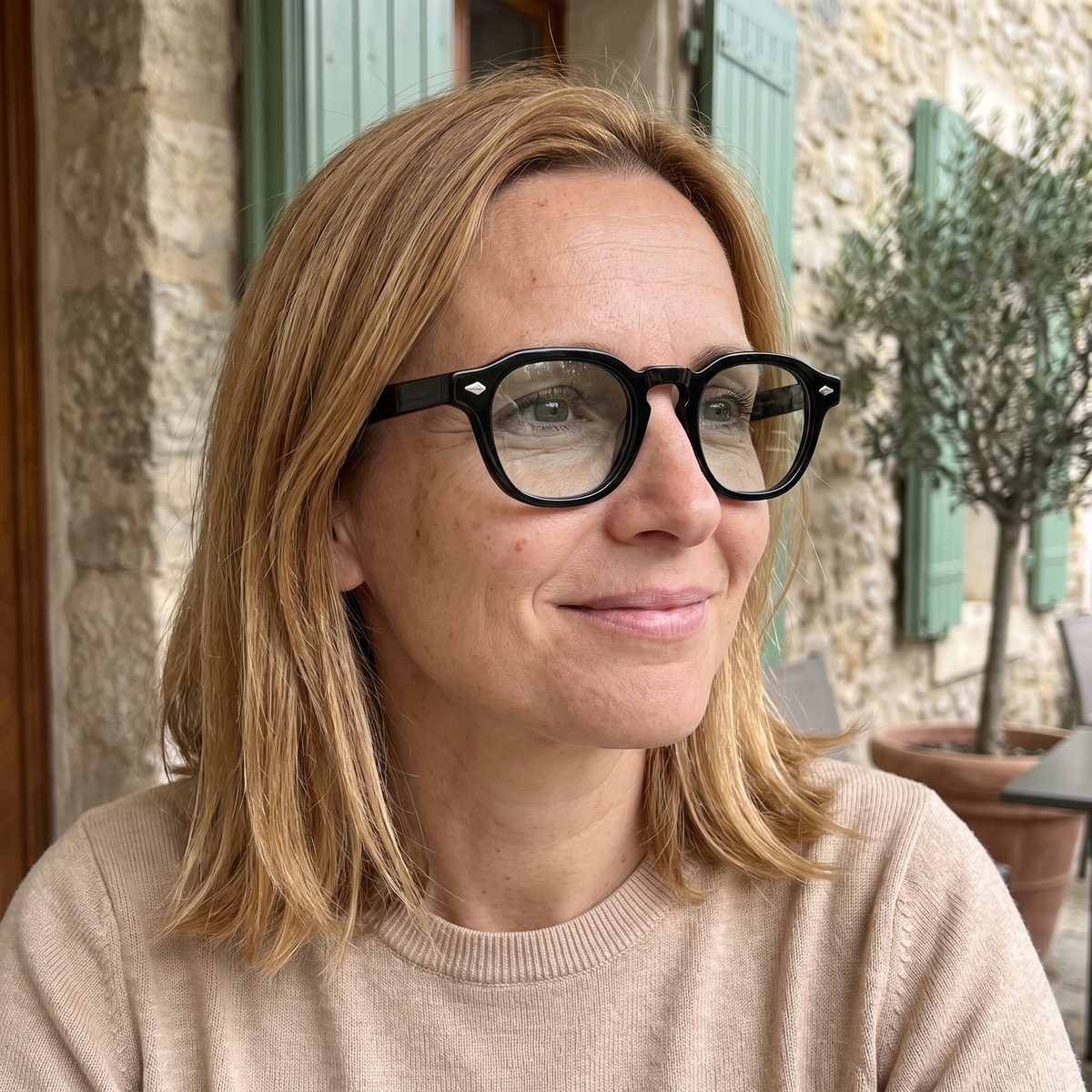 Femme portant Le Sirocco Emerald à l'ombre, monture noire brillante, verres presque clairs